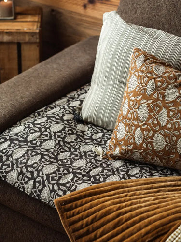 Housse de SofaCover  en coton imprimée à la main, motifs graphiques Lotus Noir. Finition passepoil élégante, déhoussable et lavable, idéale pour un intérieur éco-responsable et modulable.